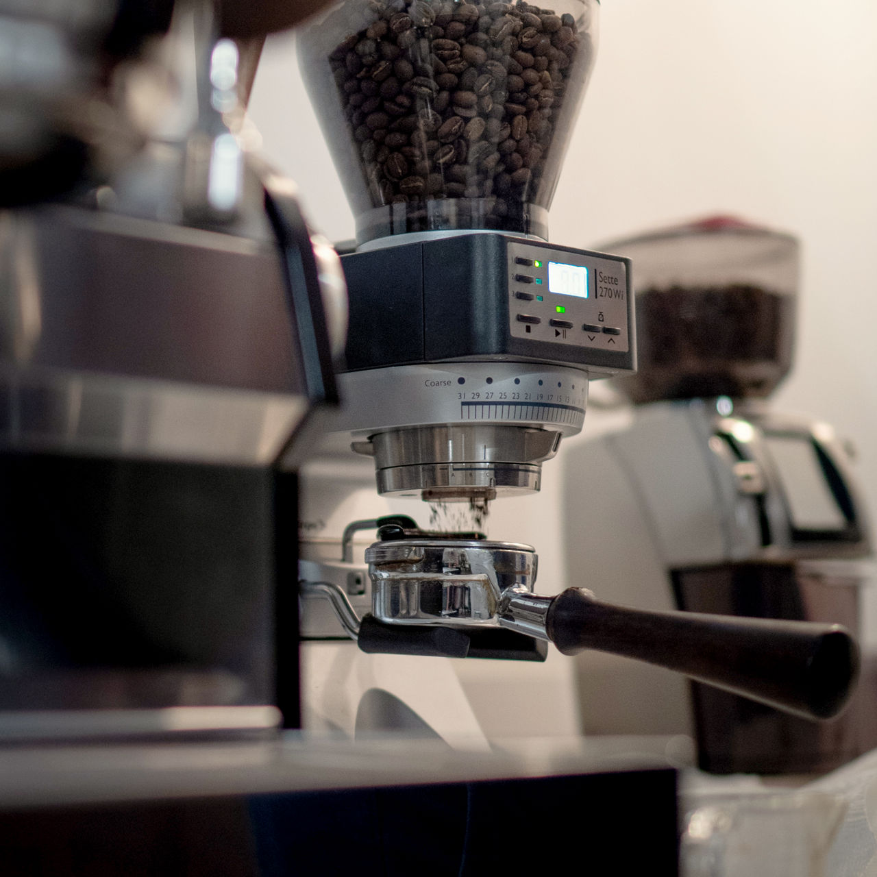 Pouring coffee from a perculator to a mug on top of a wooden benchtop.